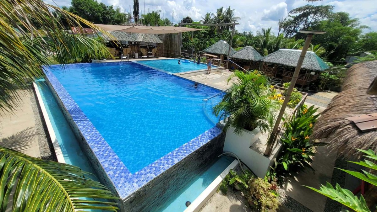 Now: the finished pool and native huts.